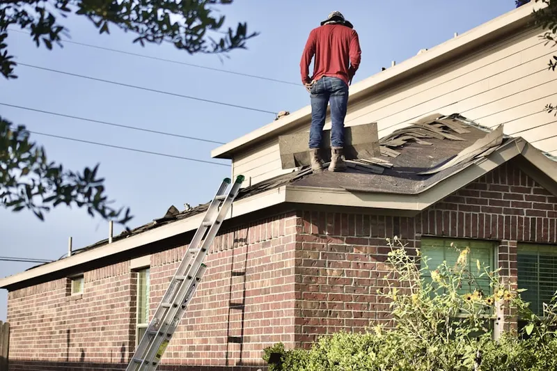 Professional roofer working on a residential roof in Neese